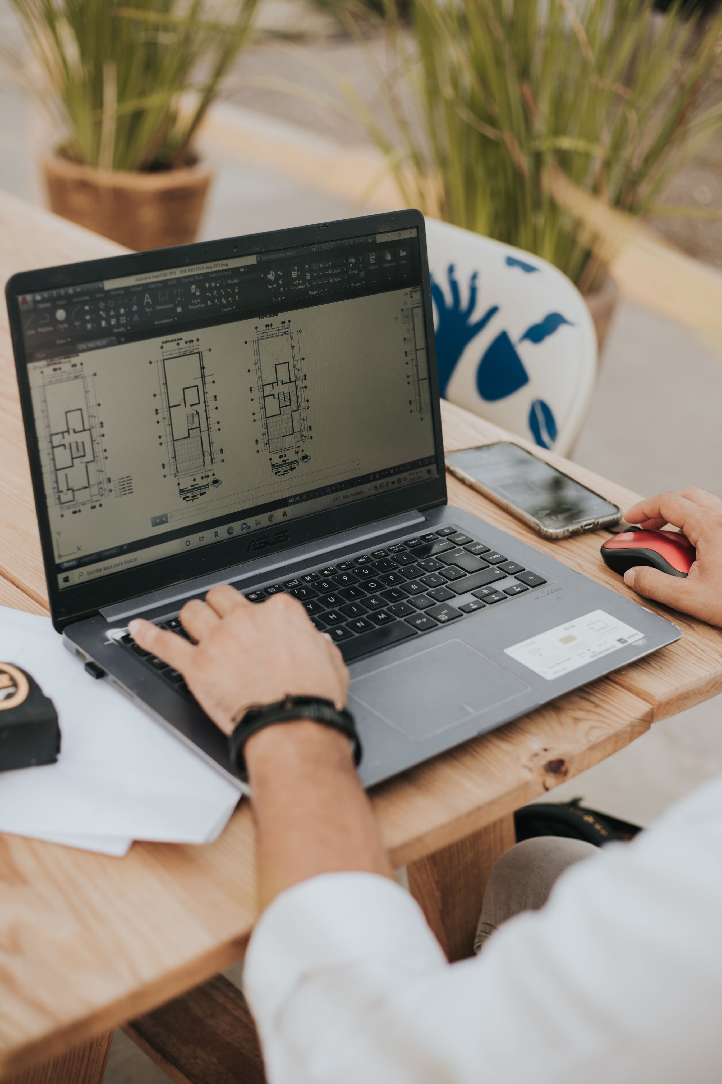 A professional reviewing construction drawings on a laptop